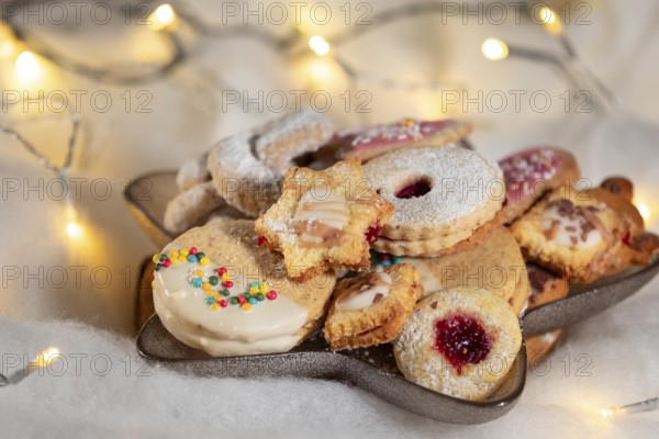 A plate full of Christmas biscuits with colourful sprinkles and soft lighting