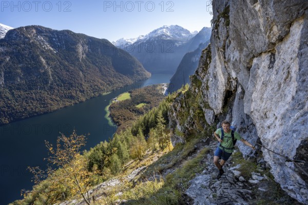 Mountaineers on a mountain hiking trail, Rinnkendlsteig, view of the Königssee, autumn forest and snow-covered mountains, Berchtesgaden National Park, Berchtesgadener Land, Upper Bavaria, Bavaria, Germany, Europe