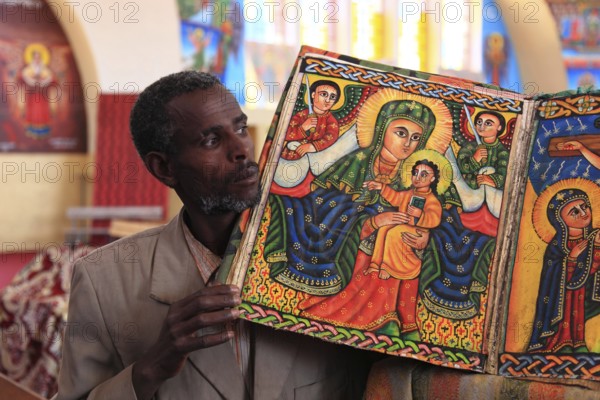 Tigray region, Axum, Aksum, St Mary's Cathedral, Maryam Tsion, inside, church servant shows old bible of the cathedral, Ethiopia, Africa