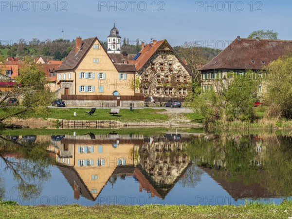 Church and historical houses of village Winterhausen, river main, reflections on the water, east of Würzburg, Germany, Europe