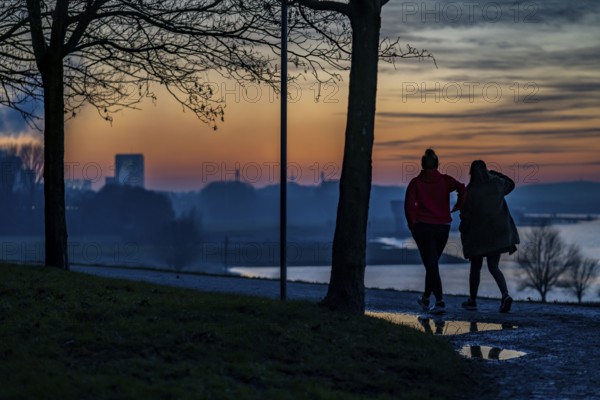 Rhine near Duisburg-Bruckhausen, walkers on the Rhine dyke, winter, Duisburg, North Rhine-Westphalia, Germany, Europe