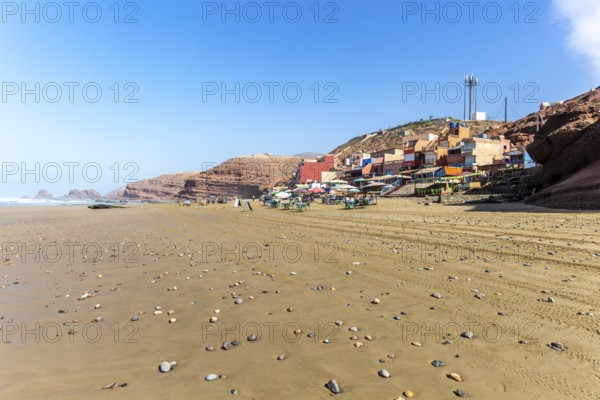 Sandy beach and buildings, Legzira, southern Morocco, north Africa