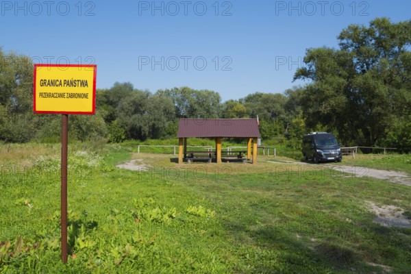 Border sign next to a wooden shelter on a green field with trees and car, motorhome, camper, border with Ukraine, Bereznica, Bereznica, Dorohusk, Horodlo, Horodlo, Hrubieszowski Voivodeship, Lublin Voivodeship, Poland, Europe