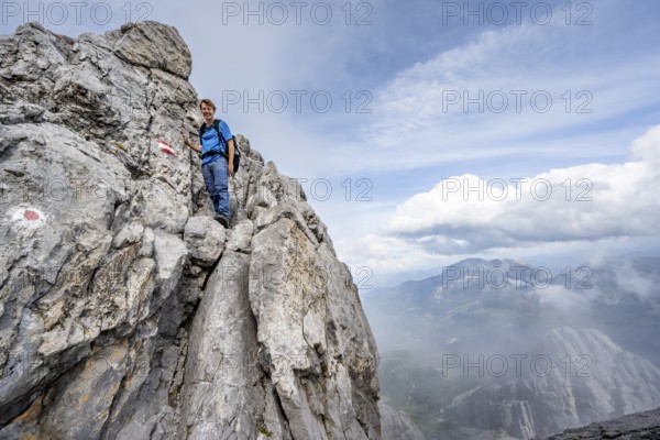 Mountaineer climbing on the rock, on a narrow rocky ridge, Watzmann crossing to the Watzmann Mittelspitze, Berchtesgaden National Park, Berchtesgaden Alps, Bavaria, Germany, Europe