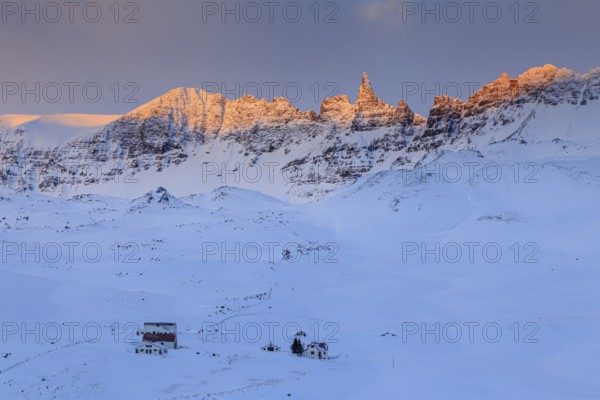 Lonely farm in front of pointed mountains in the morning light, winter, snow, Akureyri, North Iceland, Iceland, Europe