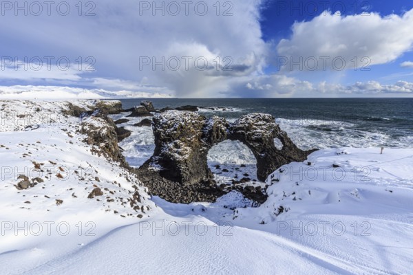 Rock gate at the coast, cliffs, snowstorm, sun, snow, winter, Arnarstapi, Snaefellsnes, Vesturland, Iceland, Europe