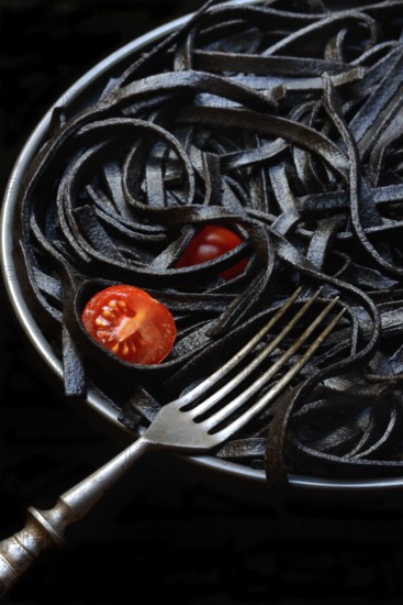 Black pasta coloured with squid ink on a plate, Taglioni al Nero di Seppia, Italy, Europe