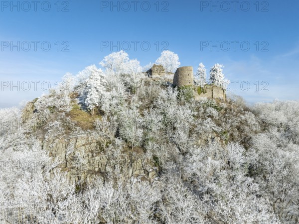 Aerial view of the snow-covered Hegau volcano Mägdeberg, with remains of a castle wall, surrounded by frosty trees in a winter landscape, district of Constance, Baden-Württemberg, Germany, Europe