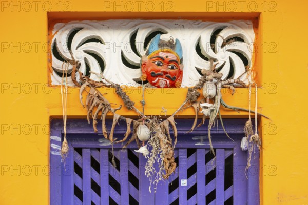 Purple-coloured front door, yellow wall, house entrance with demon mask, Rameswaram or Rameshwaram, Pamban Island, Tamil Nadu, India, Asia