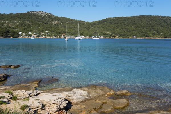 Rocky coast with blue sea and sailing boats on the horizon, ships in Kosirina Bay, Murter, Murter Island, Dalmatia, Croatia, Europe