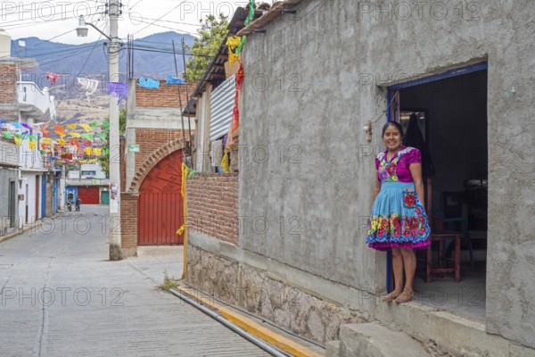 San Miguel del Valle, Oaxaca, Mexico, Epifania Hernandez Garcia stands in the doorway of her shop, where she makes elaborate aprons. Such aprons are worn by most women in this rural Mexican town. Different aprons are worn for different occasions, Central America