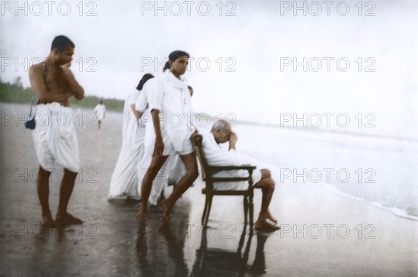 Mahatma Gandhi sitting on chair and Devdas Gandhi on Juhu Beach, Mumbai, Maharashtra, India, May 1944, Asia