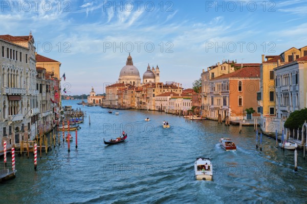 View of Venice Grand Canal with boats and Santa Maria della Salute church on sunset from Ponte dell'Accademia bridge. Venice, Italy, Europe