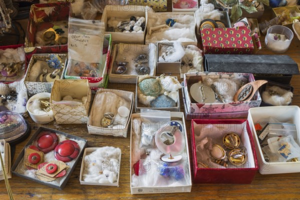 Earrings for sale displayed in boxes on table inside second hand goods and chattels store, Quebec, Canada, North America