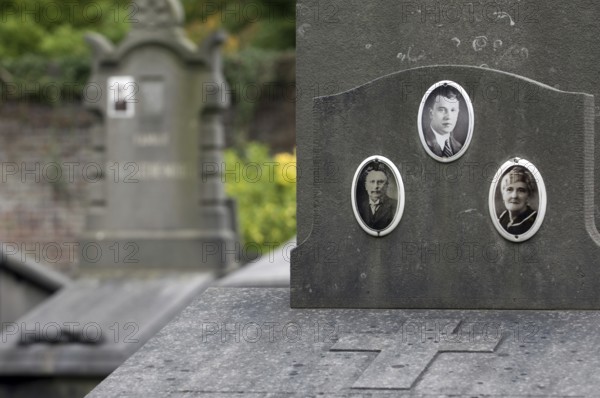 Old pictures on family grave, tomb at cemetery in autumn