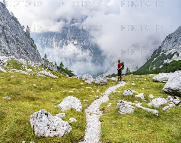 Mountaineer on a hiking trail, cloudy mountains, descent over the Ofental, mountain tour on the Hochkalter, Hochkalter crossing, Berchtesgaden Alps, Bavaria, Germany, Europe