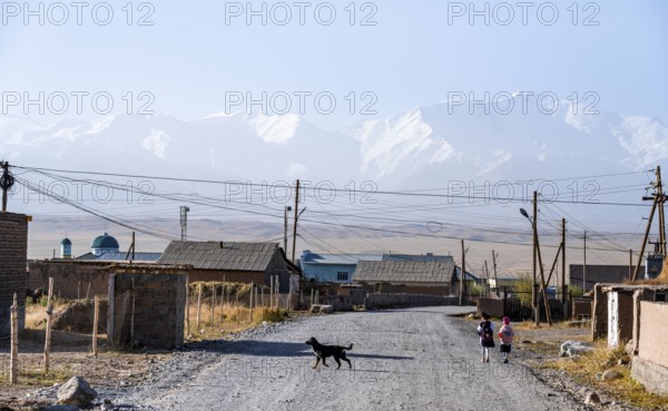 Schoolchildren and dog in the village of Sary Mogul, snow-capped mountains, Pamir Mountains, high mountains, Transalai Range, Alay District, Kyrgyzstan, Asia