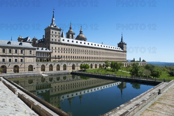 Historic monastery with reflection in the water trough under a blue sky, Real Sitio de San Lorenzo de El Escorial, Royal Seat of St Lawrence of El Escorial, palace and monastery complex, San Lorenzo de El Escorial, Madrid, Spain, UNESCO World Heritage Site, Europe