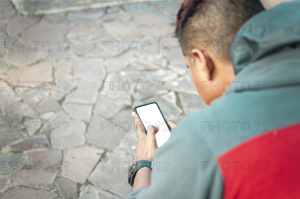 Man sitting with smartphone checking text message