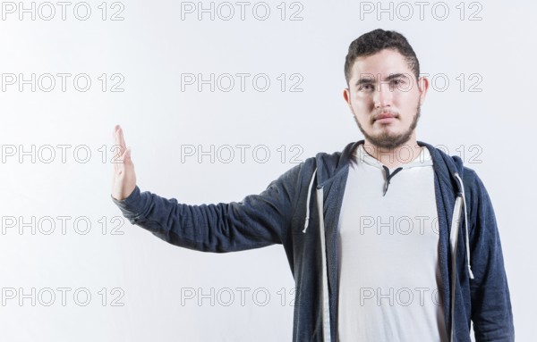 Young man making rejection gesture with palm of hand isolated. Displeased person rejecting gesturing stop isolated