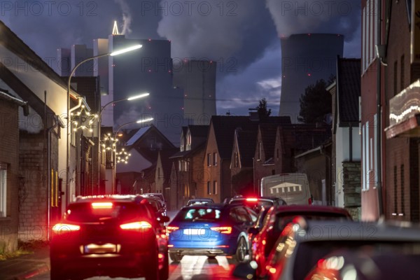 The village of Vanikum, part of the municipality of Rommerskirchen, main street, behind it the Neurath lignite-fired power plant, near Grevenbroich, thick water vapour cloud from the cooling towers in winter, near Grevenbroich, will continue to run until 2024 to secure energy supplies, North Rhine-Westphalia, Germany, Europe