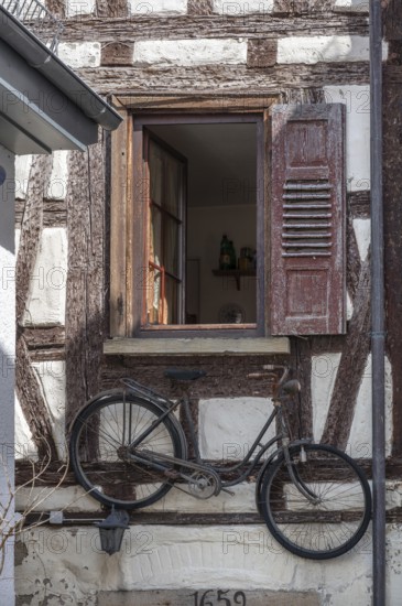 Bicycle hanging under a window of an old half-timbered house, Rottenburg, Baden-Württemberg, Germany, Europe