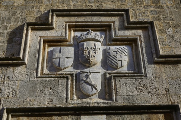 A coat of arms carved into a stone wall with various historical symbols, Knights' Street, Rhodes Old Town, Rhodes Town, Rhodes, Dodecanese, Greek Islands, Greece, Europe