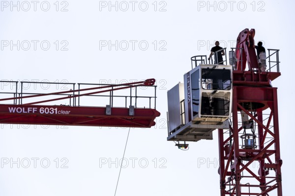 Erection of a construction crane, part of the upper crane section is hoisted by mobile crane onto an already assembled section