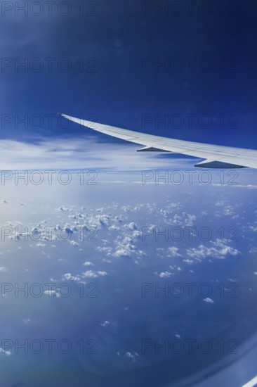 Blue sky, cloud structures over the Arabian Sea. View from the aircraft window during a flight from Phuket to Abu Dhabi with the airline Etihad. Wing of a Boeing 787 aircraft. Abu Dhabi, United Arab Emirates, UAE, Southwest Asia, Asia