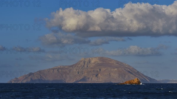 Island in the distance with rocks in the sea under blue sky, Arkasa, west coast, Kassos Island, Karpathos, Dodecanese, Greek Islands, Greece, Europe