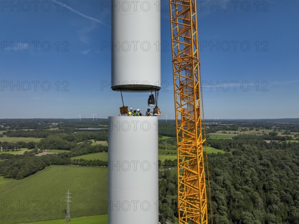 Dorsten, North Rhine-Westphalia, Germany, construction of a wind turbine, the first wind turbine of the Grosse Heide wind farm. A large mobile crane places the tower elements, the rings, on top of each other. This wind turbine will have a rated output of 5, 500 kW, Europe