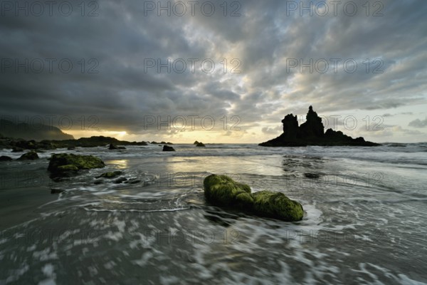 Dramatic cloudy atmosphere with rock formation at rising tide at sunset on the beach of Playa de Benijo, Tenerife, Canary Island, Spain, Europe