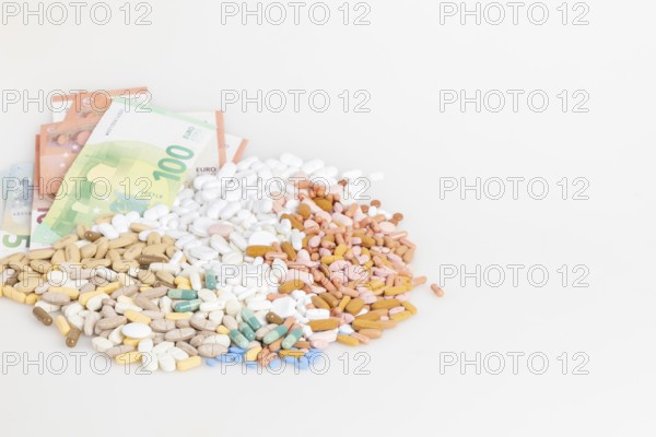 Piles of pills and banknotes on a white background, copy room