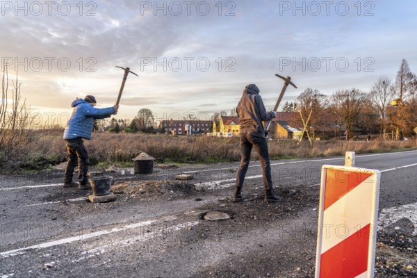 Climate activists chop up the asphalt of a road to erect obstacles, barricades, to prevent the police from evicting the occupied hamlet of Lützerath, the remains of the village are to make way for lignite mining, an eviction is imminent, North Rhine-Westphalia, Germany, Europe