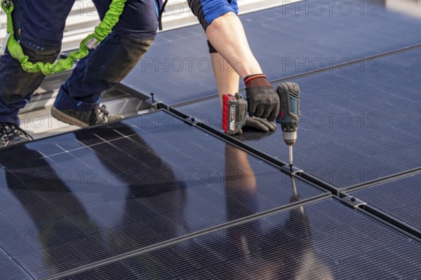 Installation of solar modules on the roof of a commercial enterprise, over 400 photovoltaic modules are installed on the roof, North Rhine-Westphalia, Germany, Europe