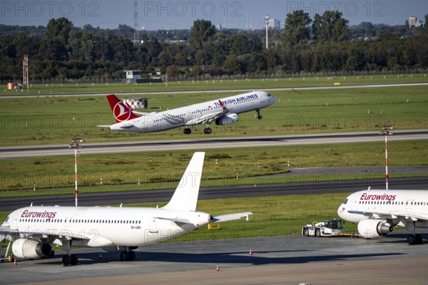 Düsseldorf Airport, Turkish Airlines Airbus A321 on take-off, Eurowings Airbus in parking position