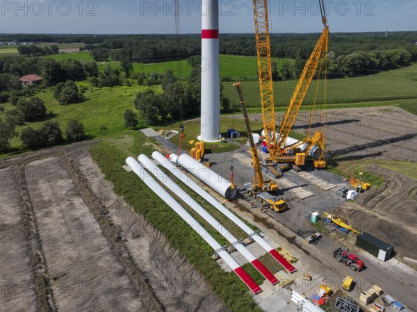 Dorsten, North Rhine-Westphalia, Germany, construction of a wind turbine, the first wind turbine of the Grosse Heide wind farm. The rotor blades are ready for assembly. A large mobile crane places the tower elements, the rings, on top of each other. This wind turbine will have a rated output of 5, 500 kW, Europe