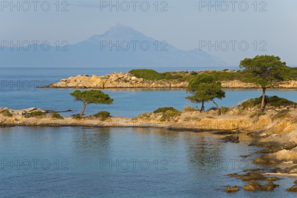 Picturesque bay with tree-covered rocks and mountain views, Karidi beach, Karydi, Mount Athos in the background, Vourvourou, Sithonia, Halkidiki, Central Macedonia, Greece, Europe