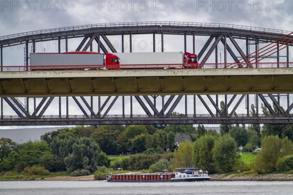 The Beeckerwerth Rhine bridge of the A42 motorway, truck traffic, behind it the Haus-Knipp railway bridge, cargo ship on the Rhine near Duisburg, North Rhine-Westphalia, Germany, Europe