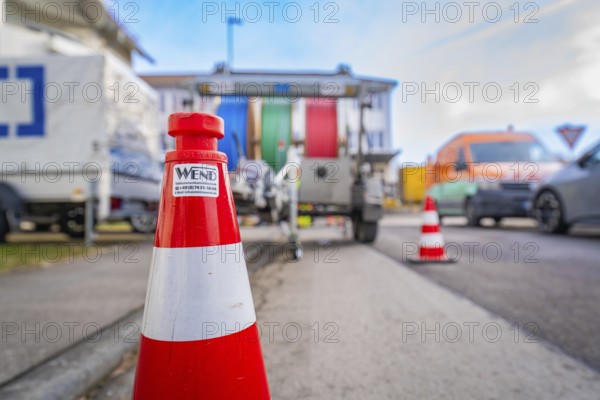 Traffic cone on a busy road with background traffic, Wend Glasfasermontage during the installation of conduits for fibre optic cables, Meßkirch, district of Sigmaringen, Germany, Europe