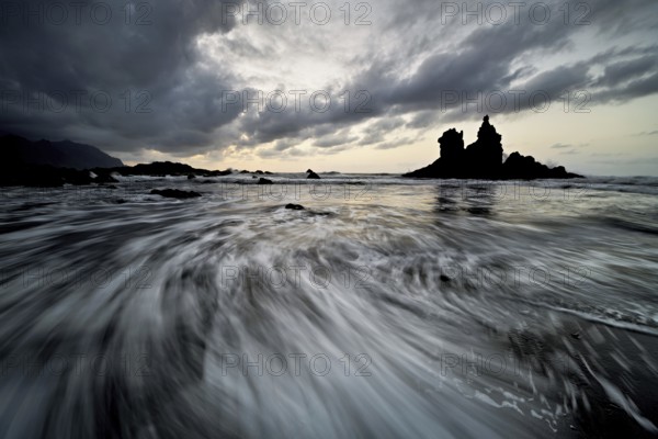 Dramatic cloudy atmosphere with rock formation at rising tide at sunset on the beach of Playa de Benijo, Tenerife, Canary Island, Spain, Europe