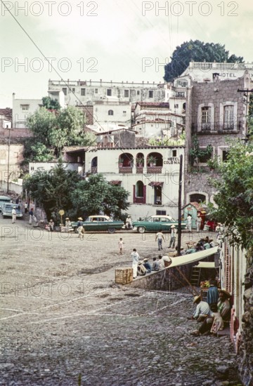 People and taxis at the Plaza bus stop, Hotel Colonia, Taxco, Guerrero state, Mexico, 1961, Central America