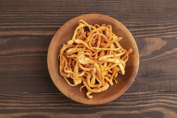 Fresh Cordyceps militaris mushrooms on brown wooden background. Top view, flat lay, copy space