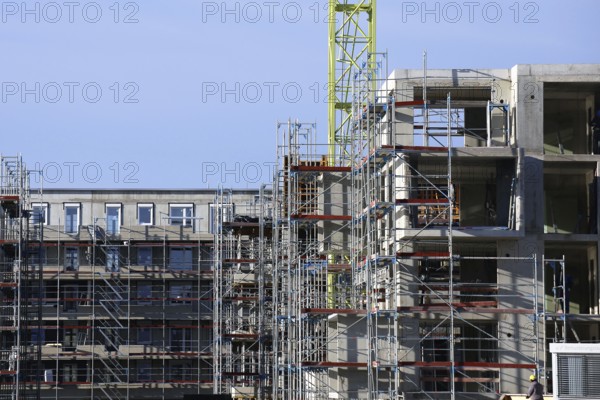 Photo of a large construction site in a newly developed residential area. Several apartment buildings are still under construction