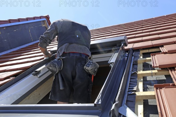 Employees of Zimmerei Mellein GmbH install the roof windows in the Mutterstadt development area, Rhineland-Palatinate