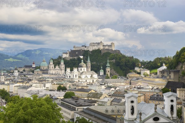 View of Salzburg with Hohensalzburg Fortress in the background and the historic city centre in the foreground, surrounded by mountains under a cloudy sky, Salzburg, Salzburger Land, Austria, Europe