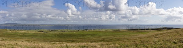 Panoramic view over wide meadows to the distant sea, Cliffs of Moher