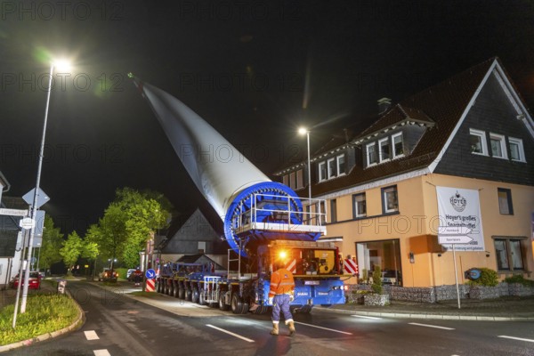 Transport of a 68 metre long, 22 tonne blade of a wind turbine, here in Breckerfeld-Waldbauer, with a self-propelled Blade-Lifter vehicle, over a 40 km long route, over 2 nights, in the Bergisches Land, through towns, villages, on country roads, narrow through roads, to the construction site of the wind turbine near Hagen, North Rhine-Westphalia, Germany, Europe