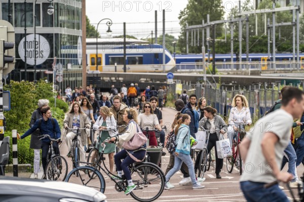 Central cycle path on Smakkelaarskade, at Utrecht Centraall station, in the centre of Utrecht, lanes for pedestrians, cyclists and cars are separated, waiting at traffic lights, heavy traffic, Netherlands