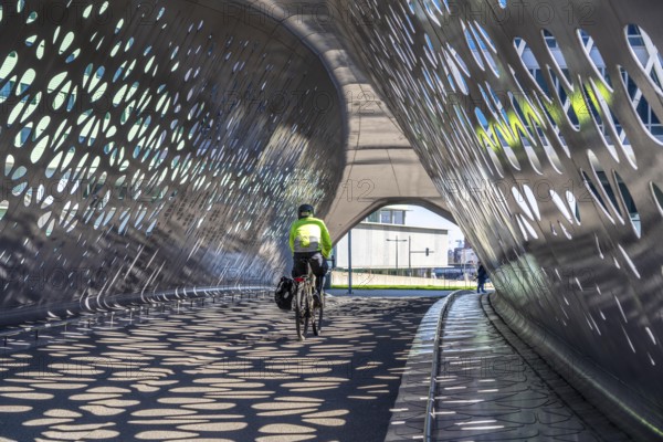 Light effects from the sun in the Parkbruk, a cycle and pedestrian bridge in the city centre of Antwerp, spanning a multi-lane city centre road with tram lines, and thus connecting two lively city districts Kop Spoor Noord and Eilandje, Belgium, without any crossings, Europe